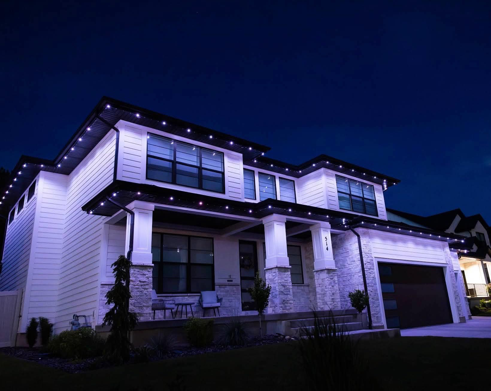 Cool-white roofline lights on a modern two-story home