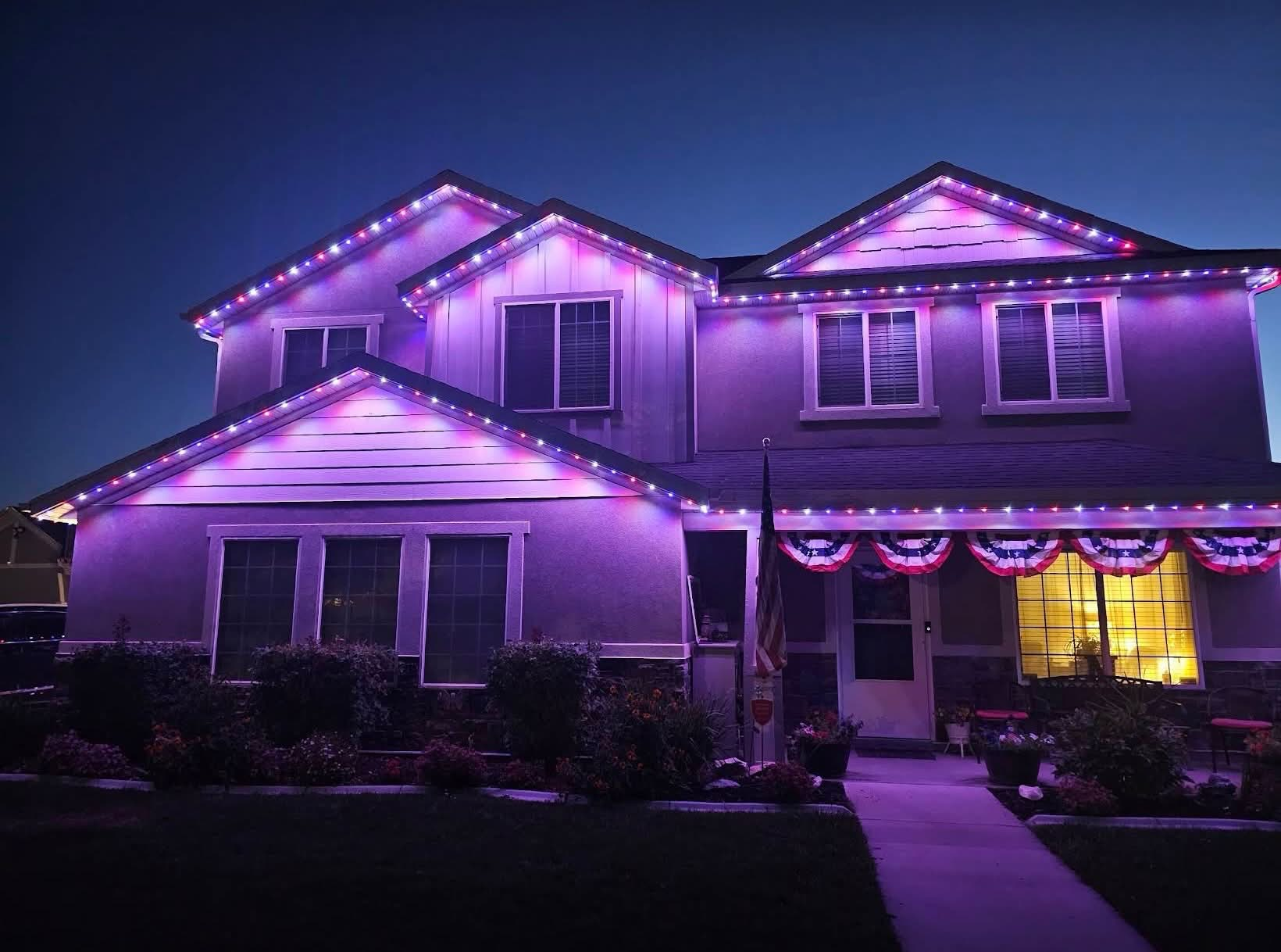 Red, white and blue permanent roofline lights on a two-story home